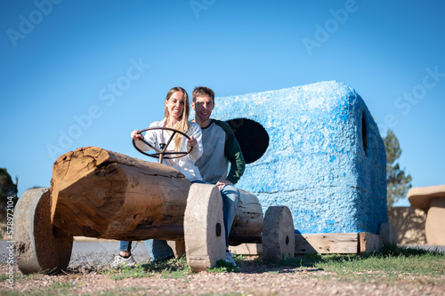Young couple riding in the flintstones flintmobile photo