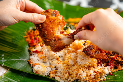 Indonesian padang food or nasi bungkus with padang fried chicken (indonesian : Ayam goreng padang)