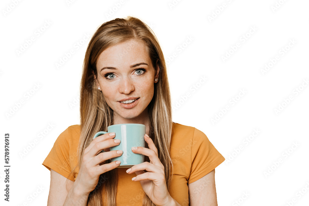 Adorable ginger young woman in orange t-shirt holds cup of tea looks at camera smiles standing against transparent background. Happy caucasian cheerful girl isolated. Adorable ginger young woman in orange t-shirt holds cup of tea looks at camera smiles standing against transparent background. Happy caucasian cheerful girl isolated.