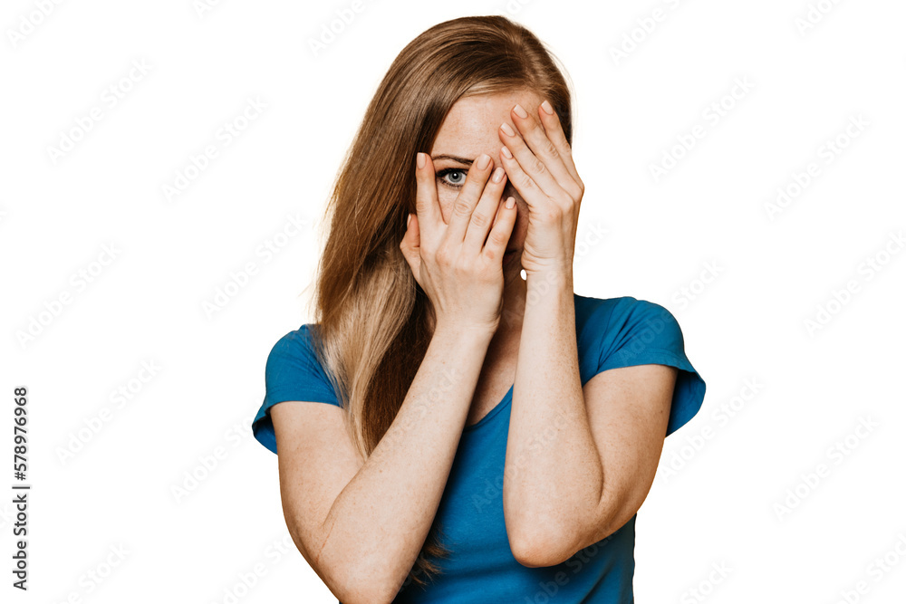Redhead ginger young woman in casual covers face by hand looks at camera through fingers stands against transparent background. Secret concept. Scared female hiding, personal data. Security concept. Redhead ginger young woman in casual covers face by hand looks at camera through fingers stands against transparent background. Secret concept. Scared female hiding, personal data. Security concept.