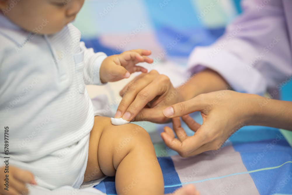 Obraz premium pediatrician Hand hold vaccine liquid injection in syringe for injecting child baby infant. small syringe needle for infant prevention flu by vaccination immunity in Pediatrics hospital clinic.