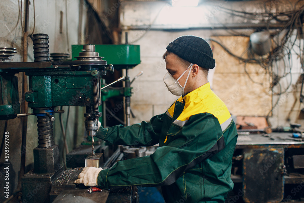 Worker with drilling boring machine works on metal factory. Worker with drilling boring machine works on metal factory.