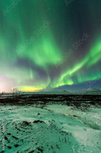 imagen de un paisaje nocturno nevado con una aurora boreal en el cielo de Islandia 