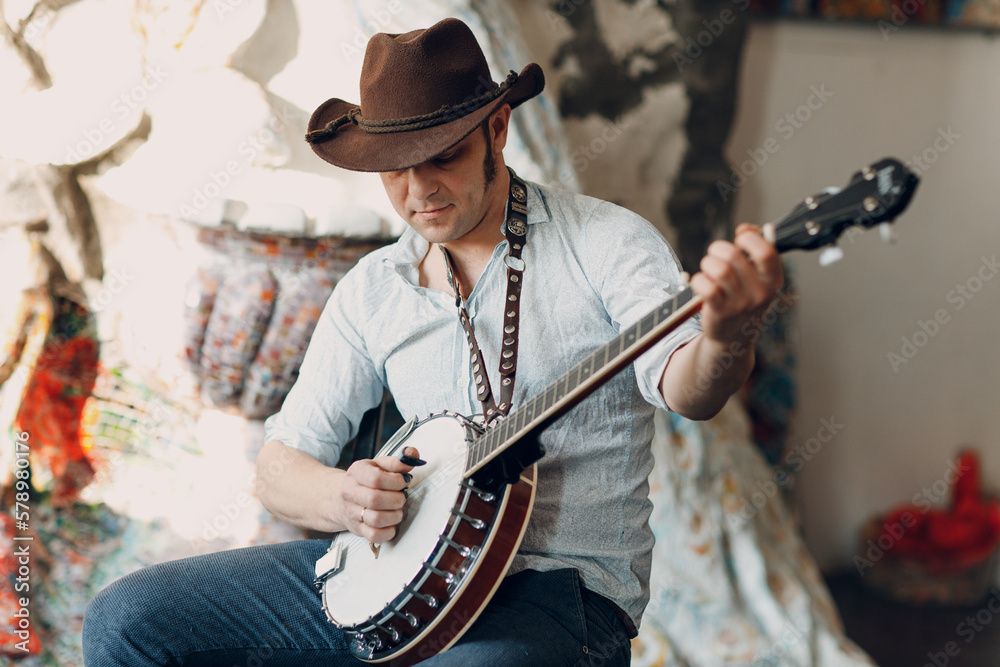 Male musician playing banjo sitting chair indoor. Male musician playing banjo sitting chair indoor.
