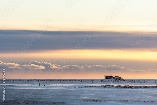 imagen de una paisaje nevado con el cielo nublado iluminado con las primeras luces del día 