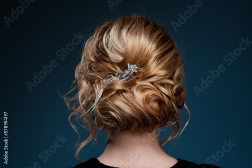 Young elegant blond woman hair styling