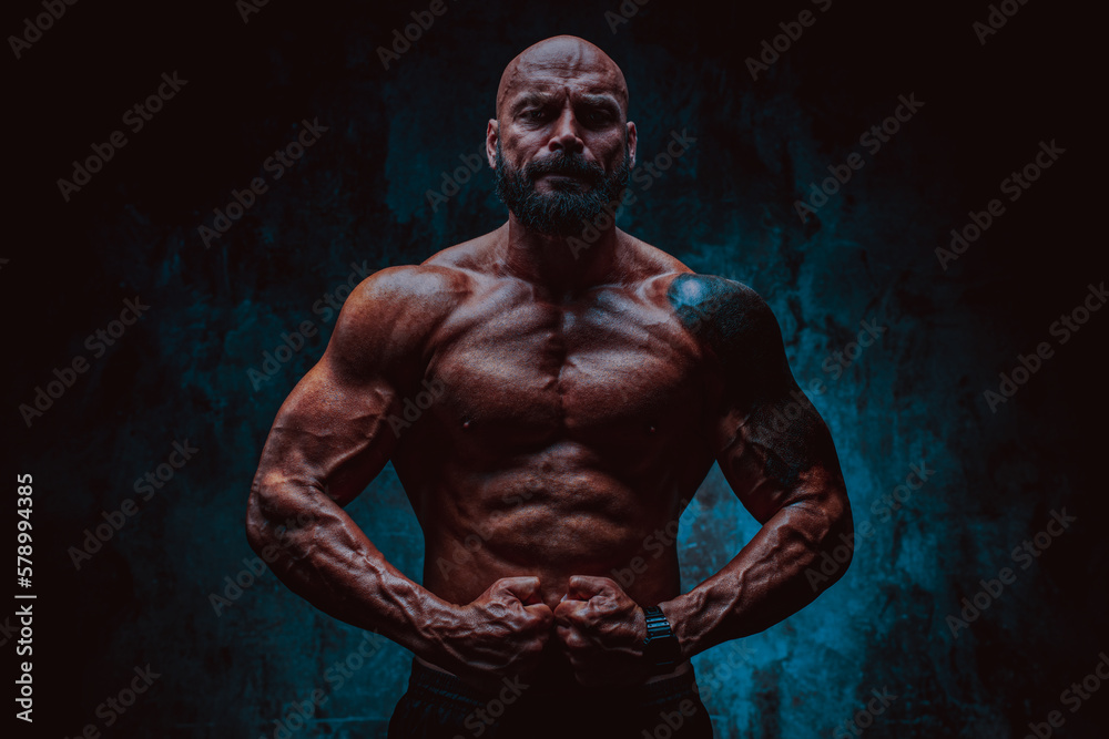 Naklejka premium Strong man bodybuilder on dark background
