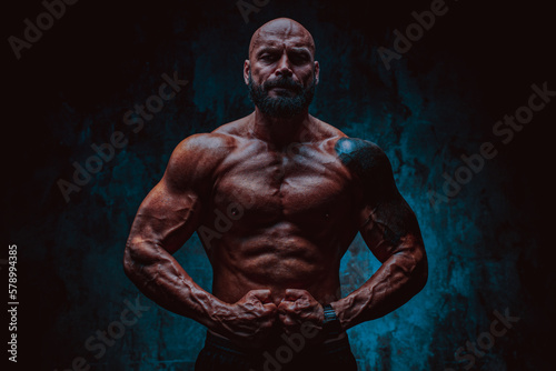 Strong man bodybuilder on dark background