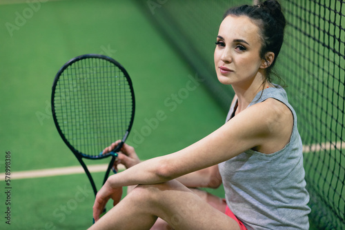 Tennis woman player portrait with racket and ball at court. © primipil