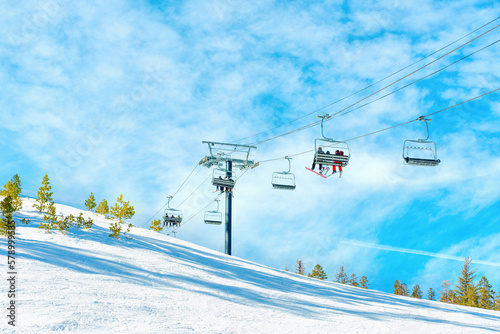 Ski Lift on Snowy Mountain Slope Against Blue Sky © Katie Chizhevskaya