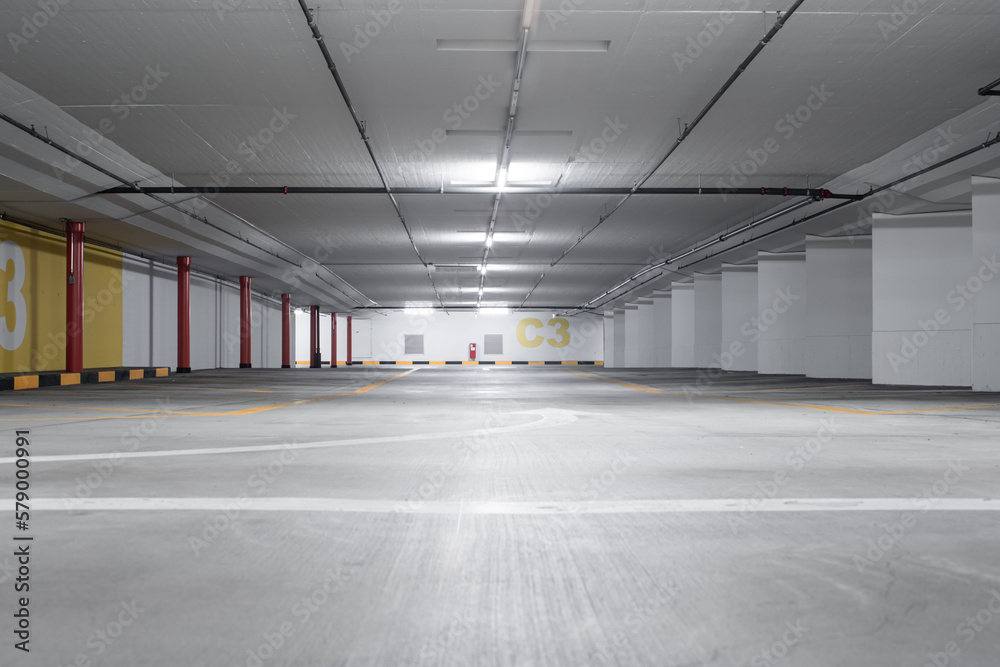 Empty underground car parking lot inEurope. Wide-angle view, neon lights, no people