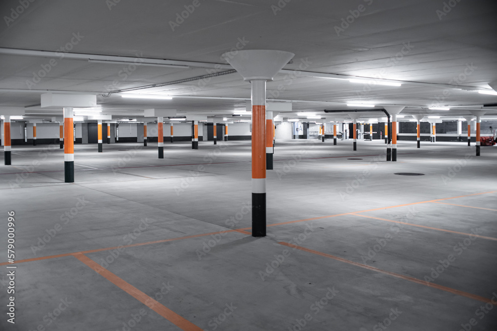 Empty underground car parking lot inEurope. Wide-angle view, neon lights, no people