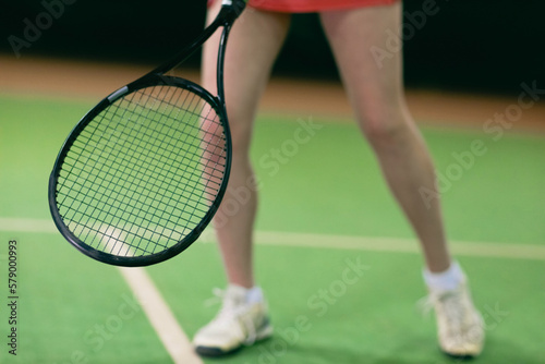 Tennis woman player legs playing training with racket and ball at court. © primipil