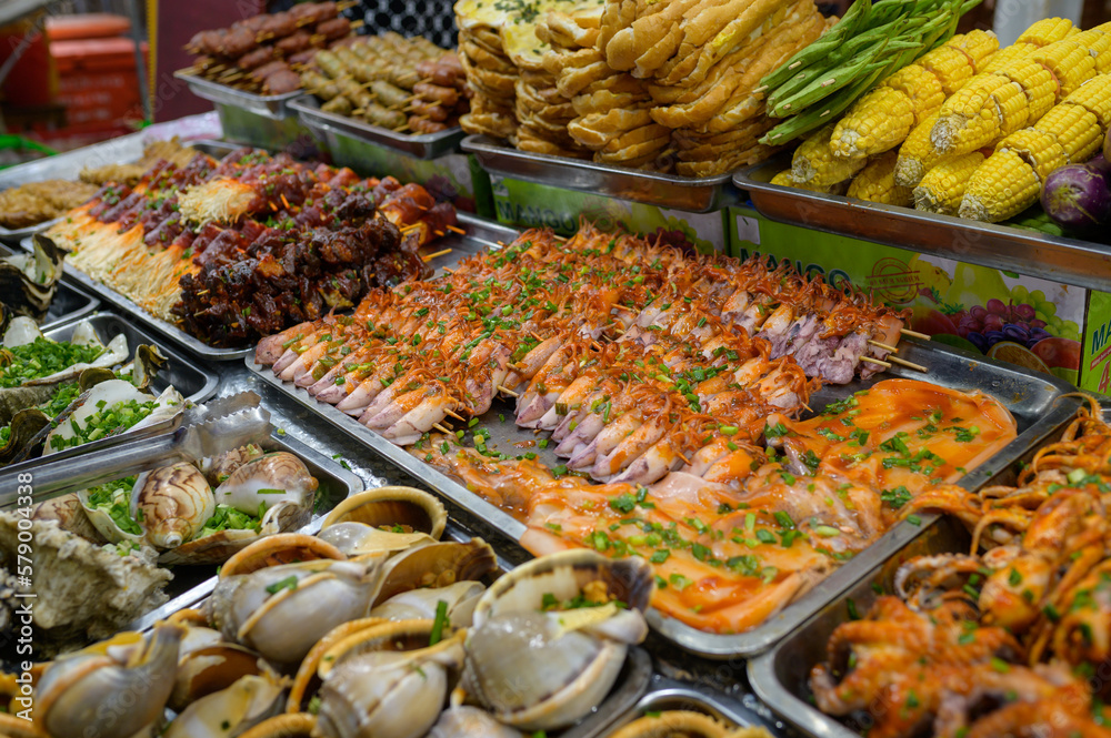 Obraz premium From above of assorted fresh seafood and boiled corns placed in containers on stall in local bazaar in Vietnam