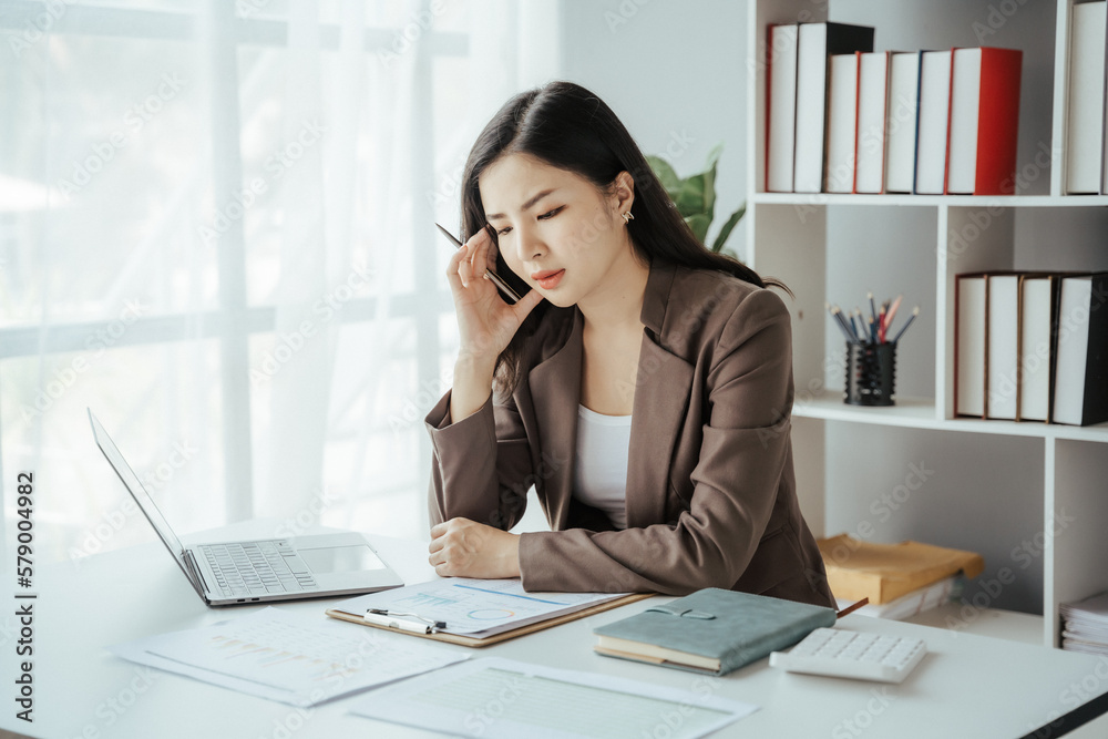Asian businesswoman in formal suit in office happy and cheerful during using smartphone and working Asian businesswoman in formal suit in office happy and cheerful during using smartphone and working