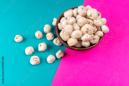 Organic Crispy Lotus pops Seeds or Phool Makhana served in a wooden bowl on background.