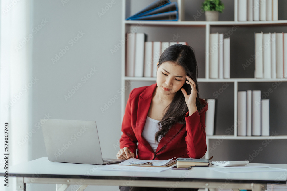 Asian businesswoman in formal suit in office happy and cheerful during using smartphone and working Asian businesswoman in formal suit in office happy and cheerful during using smartphone and working