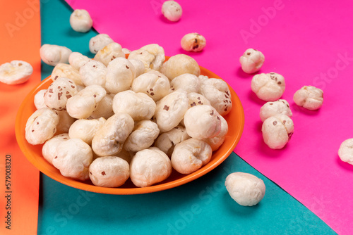 Organic Crispy Lotus pops Seeds or Phool Makhana served in a wooden bowl on background. photo