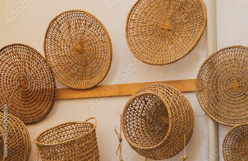 Objetos de cestería hechos con fibras naturales. Cestos y objetos decorativos a la venta expuestos colgados en la pared exterior de una tienda de Gallipoli, Italia. 