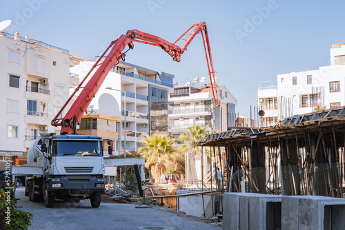 Concrete mixer truck with concrete supply pump at construction site