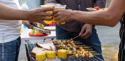 Photography Cheers! Group of young male friends drinking beer at outdoor barbecue party at home