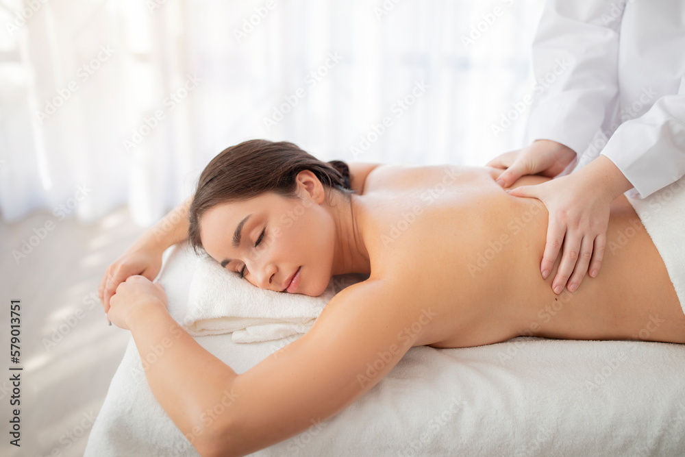 Professional masseur doing massage to beautiful indian woman in spa salon Professional masseur doing massage to beautiful indian woman in spa salon