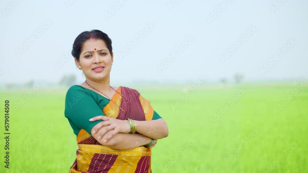 Confident village woman standing with crossed arms by looking camera at ...