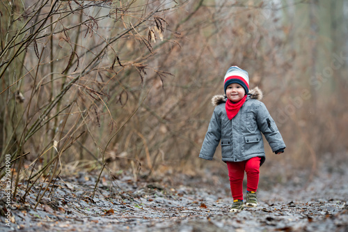 A little child is walking through the forest