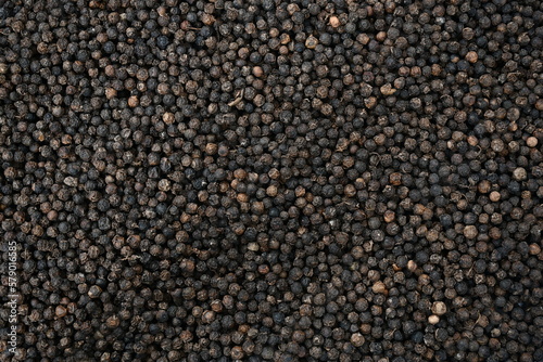 Black pepper background. black peppercorns spices. herb. bed covered in full screen. Dry black pepper seeds. Top view. Flat design. Macro spice background