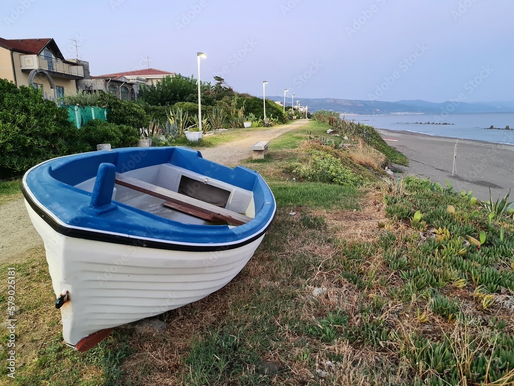 Fototapeta premium evocative close-up image of a fishing boat pulled ashore at the sea in a small fishing village in Sicily, Italy