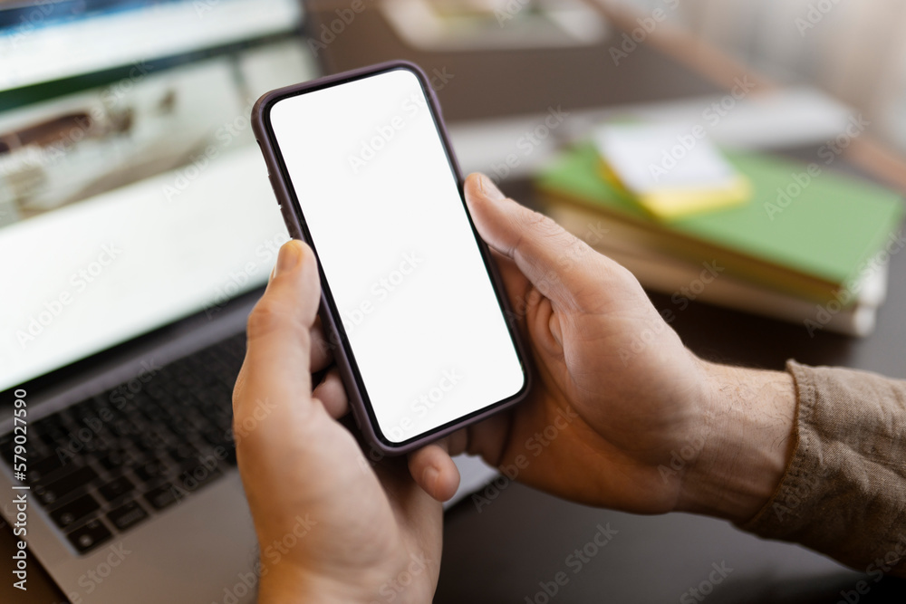 Man hand holding mobile phone using application shopping online, looking at blank display. Mockup. Male ordering food, communication, chatting, selective focus. Technology concept 