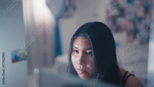 an asian teenager looks in the mirror with a feeling of insecurity because her face photo