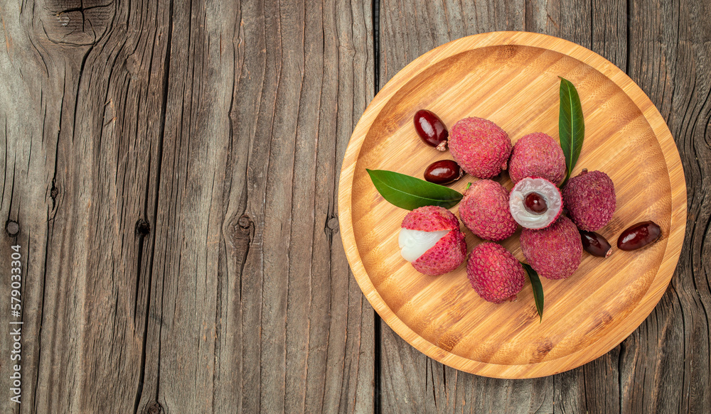 Fresh ripe lychee fruit and peeled lychee on a wooden background. banner, menu, recipe place for text, top view Fresh ripe lychee fruit and peeled lychee on a wooden background. banner, menu, recipe place for text, top view