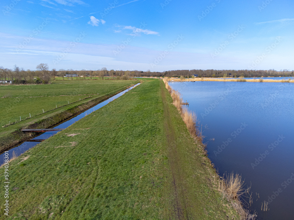 aerial shot above oldambt early spring with sunny wheater with lake, water and blue sky