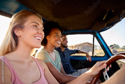 Group Of Friends On Road Trip Driving In Cab Of Pick Up Truck