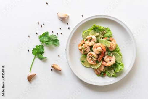 Healthy food stir fried shrimp lemon garlic in bowl on white table.