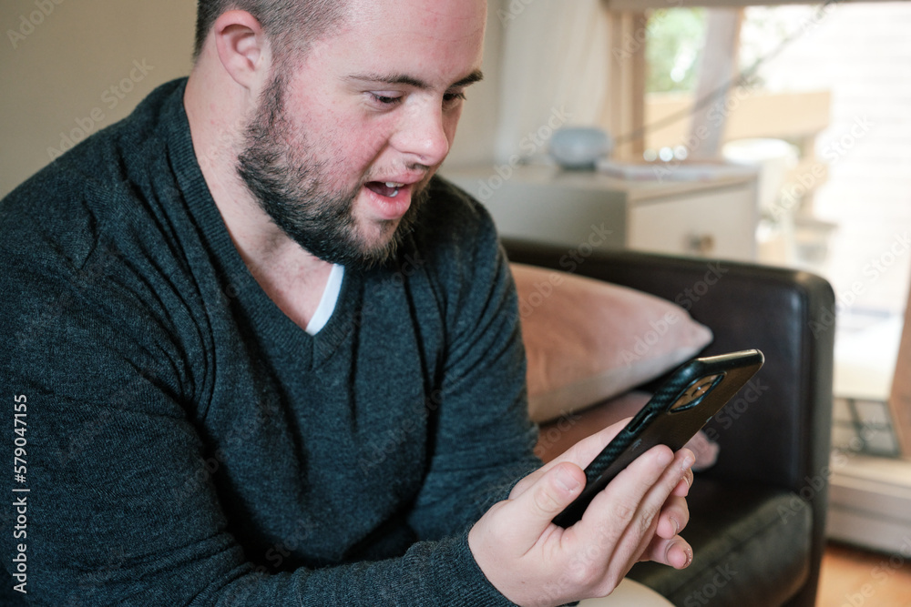 Young Man with Down Syndrome holding Mobile Phone Young Man with Down Syndrome holding Mobile Phone