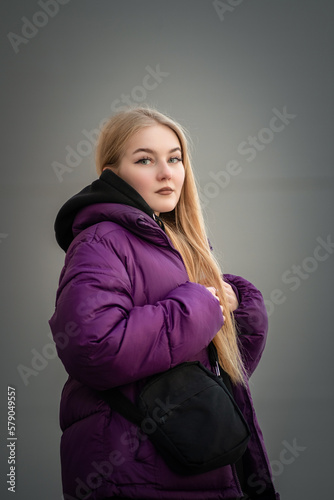 Portrait of a young beautiful fair-haired girl on a spring street.
