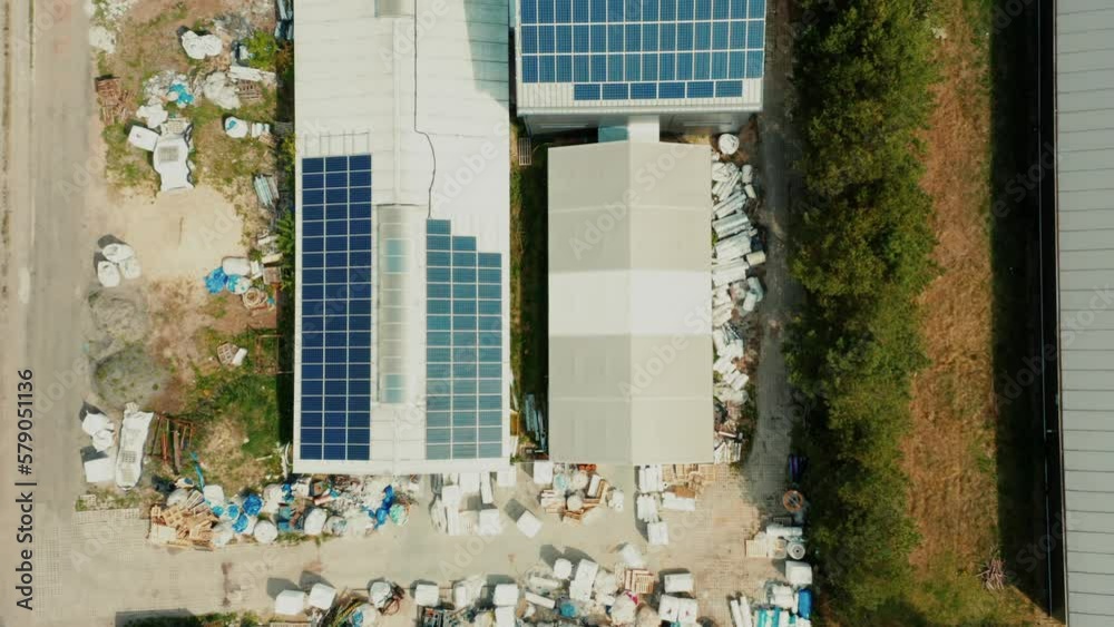 Roof of an industrial building with solar panels top view. Production of renewable energy concept. aerial view of photovoltaic solar panels installed on the roof building to produce green electricity Roof of an industrial building with solar panels top view. Production of renewable energy concept. aerial view of photovoltaic solar panels installed on the roof building to produce green electricity