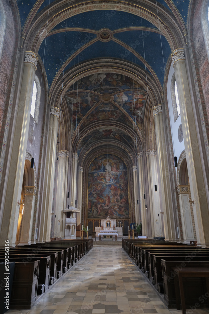 Monumental church building in Gothic in neo-romanesque arch style with large ceiling and altar murals and fresco, opulent detailed columns and marble structures