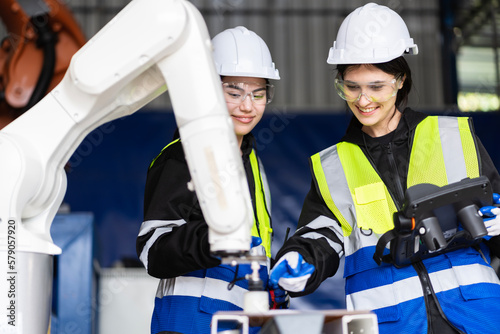 A team of female engineers meeting to inspect computer-controlled steel welding robots. Plan for rehearsals and installation for use.