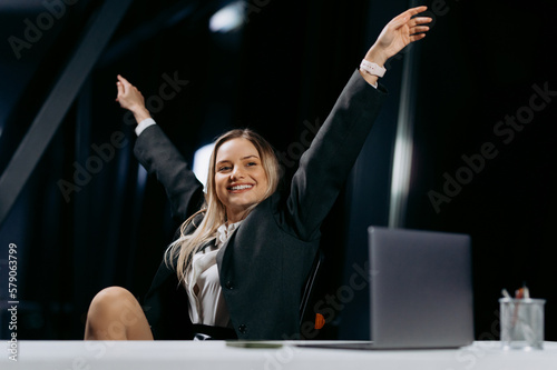 a young girl in classic clothes is happy at the desk. the end of the working day