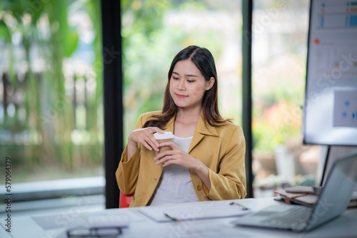 Happy businesswoman Holding a cup of coffee and smiling analyzing weekly schedule in the office Free Download Happy businesswoman Holding a cup of coffee and smiling analyzing weekly schedule in the office - GFXLoad