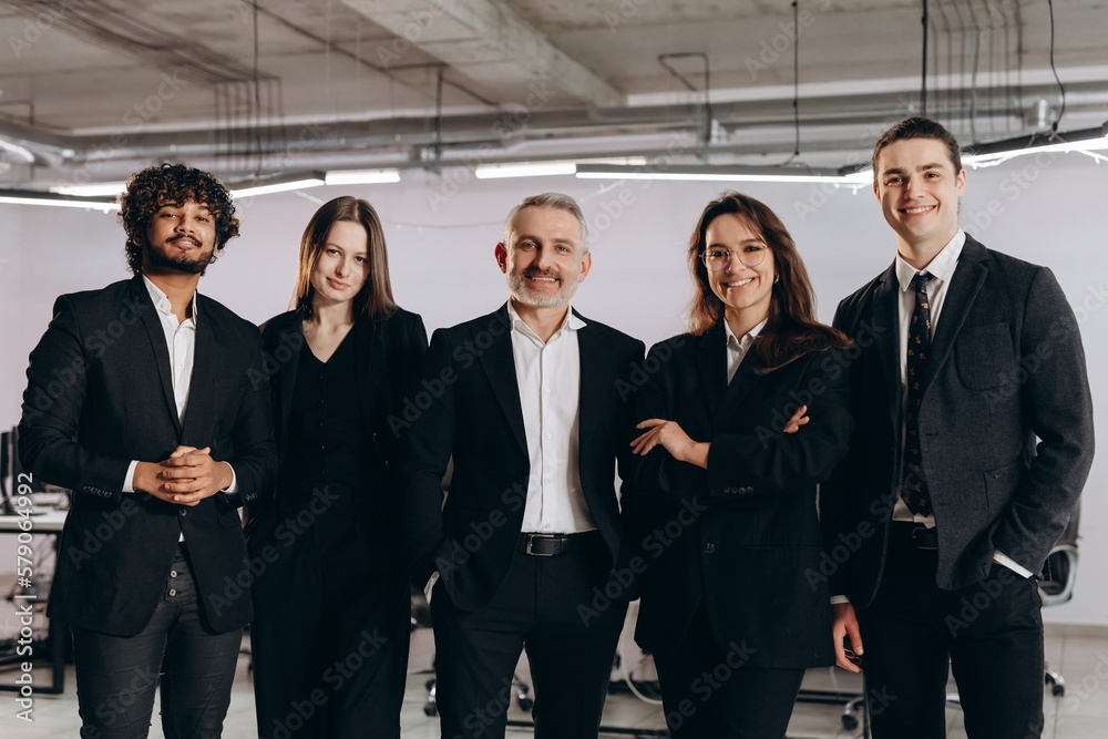 Team of businessmen standing in confident pose. Ambitious business specialists posing with smile in office. Career growth, startup owners Team of businessmen standing in confident pose. Ambitious business specialists posing with smile in office. Career growth, startup owners