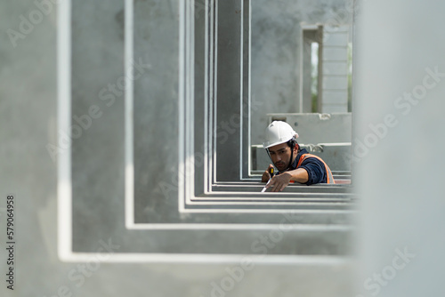 Male engineers are inspecting and controlling the work of the employees and the quality of the manufactured products to meet the standards In industrial factories producing precast prefabricated walls photo