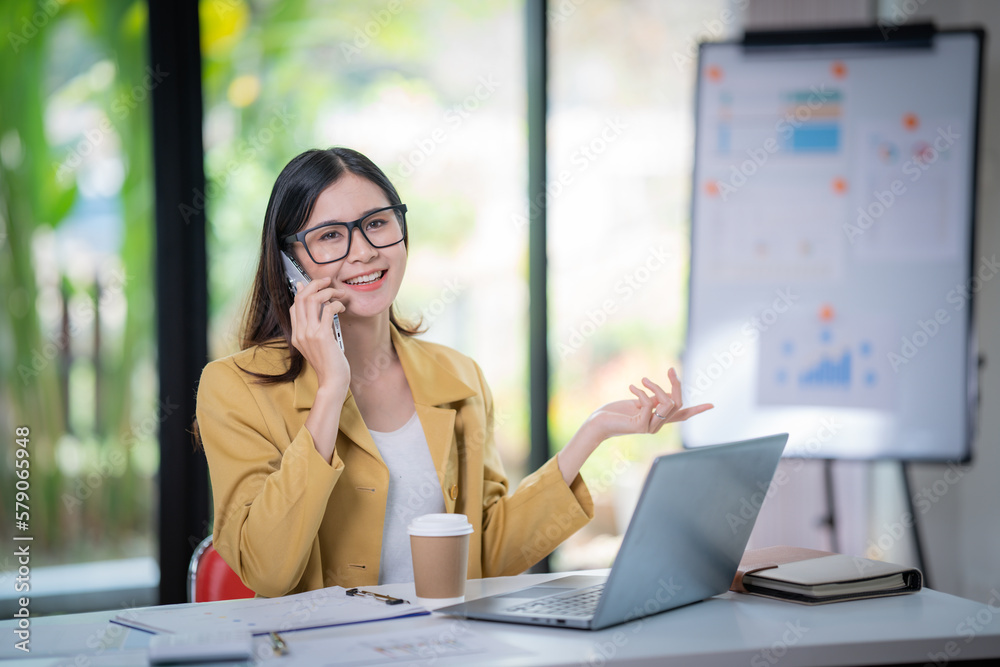 Happy businesswoman talking on mobile phone while analyzing weekly schedule in the office. Happy businesswoman talking on mobile phone while analyzing weekly schedule in the office.