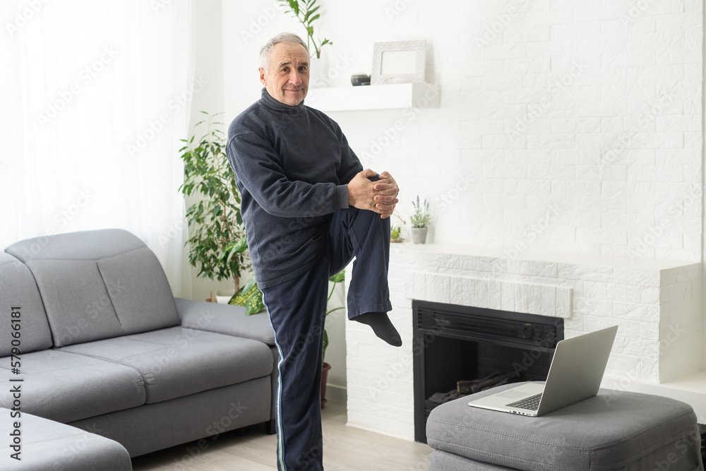 Mature aged man watching video training tutorial online, vlogging and blogging at home on lockdown