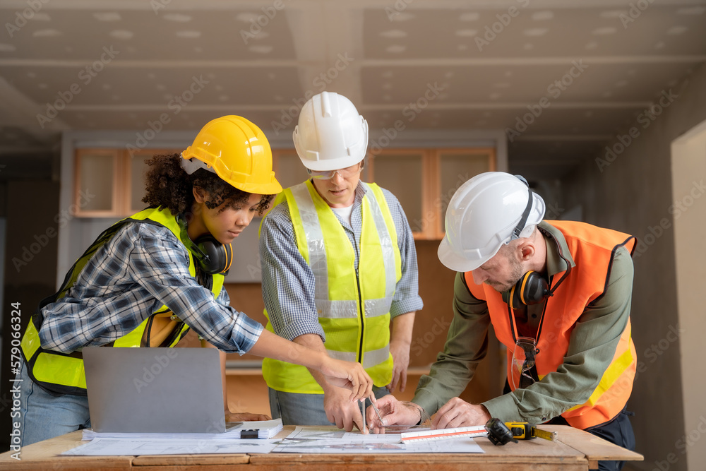 Architect colleagues mixed race working as a team discussing data working and tablet, laptop with on on architectural project at construction site at desk. Architect colleagues mixed race working as a team discussing data working and tablet, laptop with on on architectural project at construction site at desk.