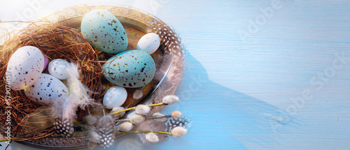 Easter holiday decoration on blue wooden background; sunny Easter morning