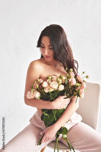 Beautiful young woman with bouquet flowers of roses. International Women's Day.
